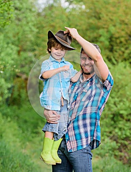 Happy earth day. Eco farm. small boy child help father in farming. father and son in cowboy hat on ranch. kid in rubber