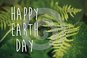 Happy earth day text, concept. beautiful fern leaf and moss in
