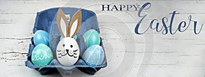 Happy Easter background banner panorama greeting card -Close-up from colorful painted eggs / easter bunnies in blue egg carton on