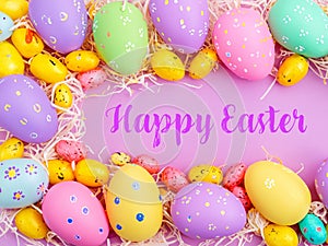 Happy Easter Banner with multiple coloured Easter eggs surrounded by straw