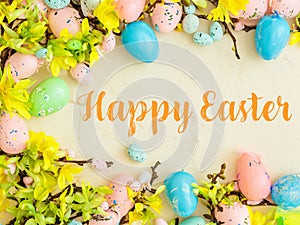 Happy Easter Banner with multiple coloured Easter eggs surrounded by spring flowers