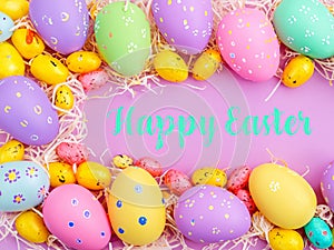 Happy Easter Banner with multiple coloured Easter eggs surrounded by straw