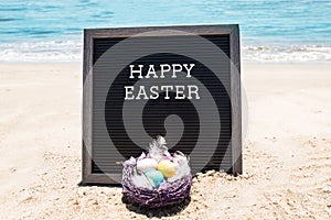 Happy Easter beach background with black board and basket