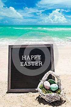 Happy Easter beach background with black board and basket