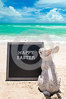 Happy Easter beach background with black board and bunny