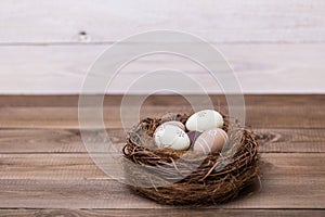 Happy easter! Beautiful Easter eggs are decorated in bed colors in a nest on a wooden background. Easter conceptual