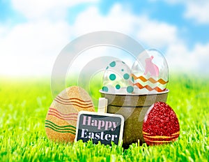 Happy Easter on black clip board with colorful easter eggs on gr