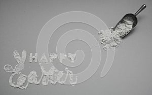 Happy Easter card isolated on the background. Handmade lettering with flour with Easter logo first letter in the form of rabbit. photo