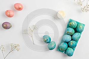 Happy easter card. Stylish minimalistic composition of turquoise with gold easter eggs on a white background. Candles