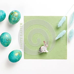 Happy easter card. Stylish minimalistic composition of turquoise with gold easter eggs on a white background. Figurine