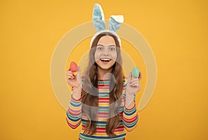 happy easter child girl in rabbit bunny ears showing painted eggs for holiday, happy easter