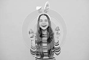 happy easter child girl in rabbit bunny ears showing painted eggs for holiday, happy easter