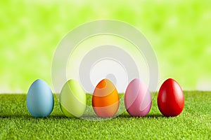 Happy Easter - Colored eggs on grass and green abstract background