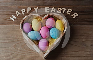 Happy Easter - colored eggs in a heart shaped bowl