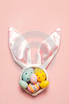 Happy Easter. Colorful easter painted eggs on white bunny ears with copy space for text