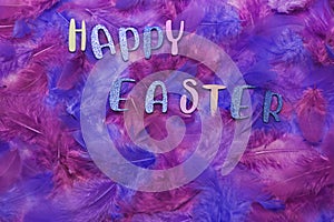 `Happy Easter` on colorful feathers with copy space
