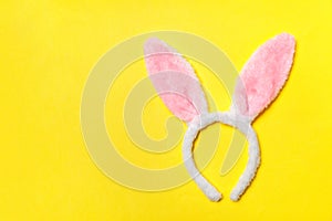 Happy Easter concept. Decorative bunny ears furry costume toy isolated on trendy yellow background