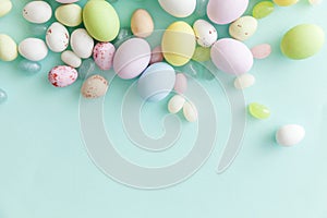 Happy Easter concept. Easter candy chocolate eggs and jellybean sweets isolated on trendy pastel blue background. Simple