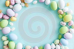 Happy Easter concept. Easter candy chocolate eggs and jellybean sweets isolated on trendy pastel blue background. Simple