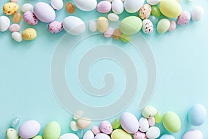 Happy Easter concept. Easter candy chocolate eggs and jellybean sweets isolated on trendy pastel blue background. Simple