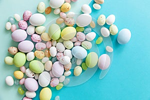 Happy Easter concept. Easter candy chocolate eggs and jellybean sweets isolated on trendy pastel blue background. Simple