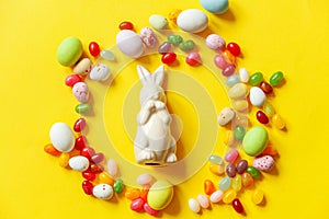 Happy Easter concept. Preparation for holiday. Easter candy chocolate eggs bunny and jellybean sweets isolated on trendy yellow