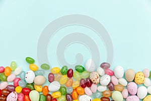 Happy Easter concept. Preparation for holiday. Easter candy chocolate eggs and jellybean sweets isolated on trendy pastel blue