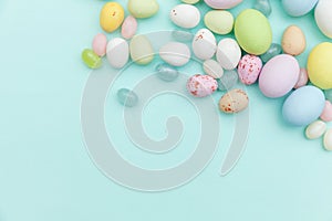 Happy Easter concept. Preparation for holiday. Easter candy chocolate eggs and jellybean sweets isolated on trendy pastel blue