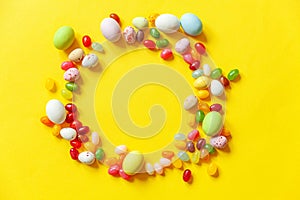 Happy Easter concept. Preparation for holiday. Easter candy chocolate eggs and jellybean sweets isolated on trendy yellow