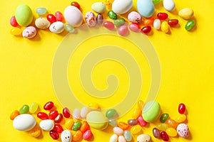 Happy Easter concept. Preparation for holiday. Easter candy chocolate eggs and jellybean sweets isolated on trendy yellow