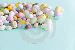 Happy Easter concept. Preparation for holiday. Easter candy chocolate eggs and jellybean sweets  on trendy pastel blue