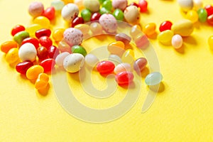 Happy Easter concept. Preparation for holiday. Easter candy chocolate eggs and jellybean sweets  on trendy yellow