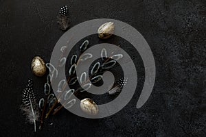 Happy Easter concept. Preparation for holiday. Golden decorated easter eggs willow feather on trendy grunge scratched dark black