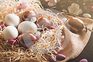 Happy Easter. Congratulatory easter background. Easter eggs on a metal plate with spring flowers on a wooden background