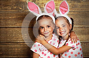 Happy easter! cute twins girls sisters dressed as rabbits on wo