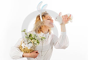 Happy Easter day. Smiling girl in bunny ears with basket eggs and Easter rabbit.