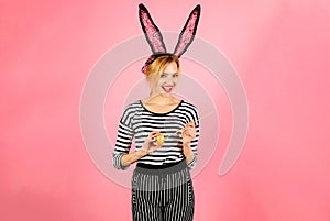 Happy easter day. Smiling woman in bunny ears painting Easter egg. Painted eggs for Easter. Easter bunny girl. Color egg