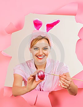 Happy Easter day. Smiling woman in bunny ears painting Easter eggs. Egg hunt. Easter day concept. Happy girl in rabbit