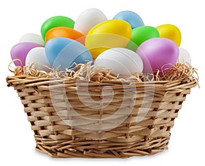 happy Easter decoration, wicker basket full of colored easter eggs in pastel light colors on straw nest, isolated on background.