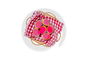 Happy easter decorations background. Top view of colorful easter eggs in a basket on red checkered napkin isolated on a white