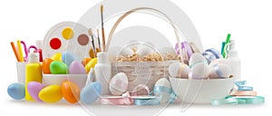 Happy Easter decorations, basket eggs with light pastel colored bright ribbons and colors of painting, isolated on white
