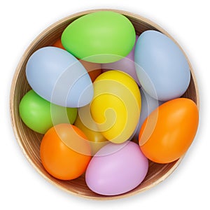 Happy Easter decorations, basket full of colored easter eggs in pastel light colors, top view on white background. Template for