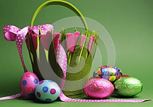 Easter egg hunt with colorful Spring theme polka dot carry basket bag and chocolate Easter eggs photo