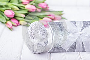 Happy Easter. Easter egg and pink tulips on a white background