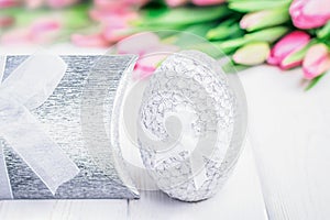 Happy Easter. Easter egg and pink tulips on a white background