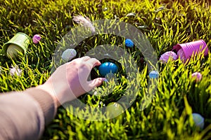 Happy Easter. Easter eggs hidden in spring grass. Woman holding egg