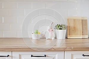 Happy Easter! Easter Eggs, Rabbit, Cutting Boards, Succulent On The Kitchen Counter. Bright And Clean Rustic Kitchen With White