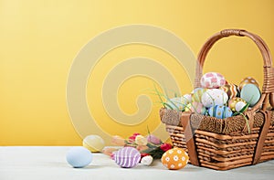 Happy easter, Easter painted eggs in the basket on wooden rustic table for your decoration in holiday. copy space