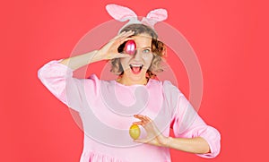 Happy Easter. Egg hunt. Girl with color eggs. Smiling woman in rabbit bunny ears prepare for Easter.