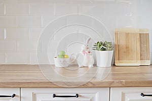 Happy Easter! Easter Eggs, Rabbit, Cutting Boards, Succulent On The Kitchen Counter. Bright And Clean Rustic Kitchen With White photo
